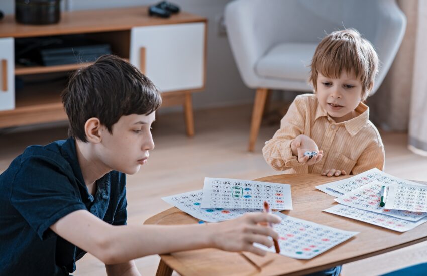 two brothers play a three-in-a-row puzzle game. Family leisure, big brother care