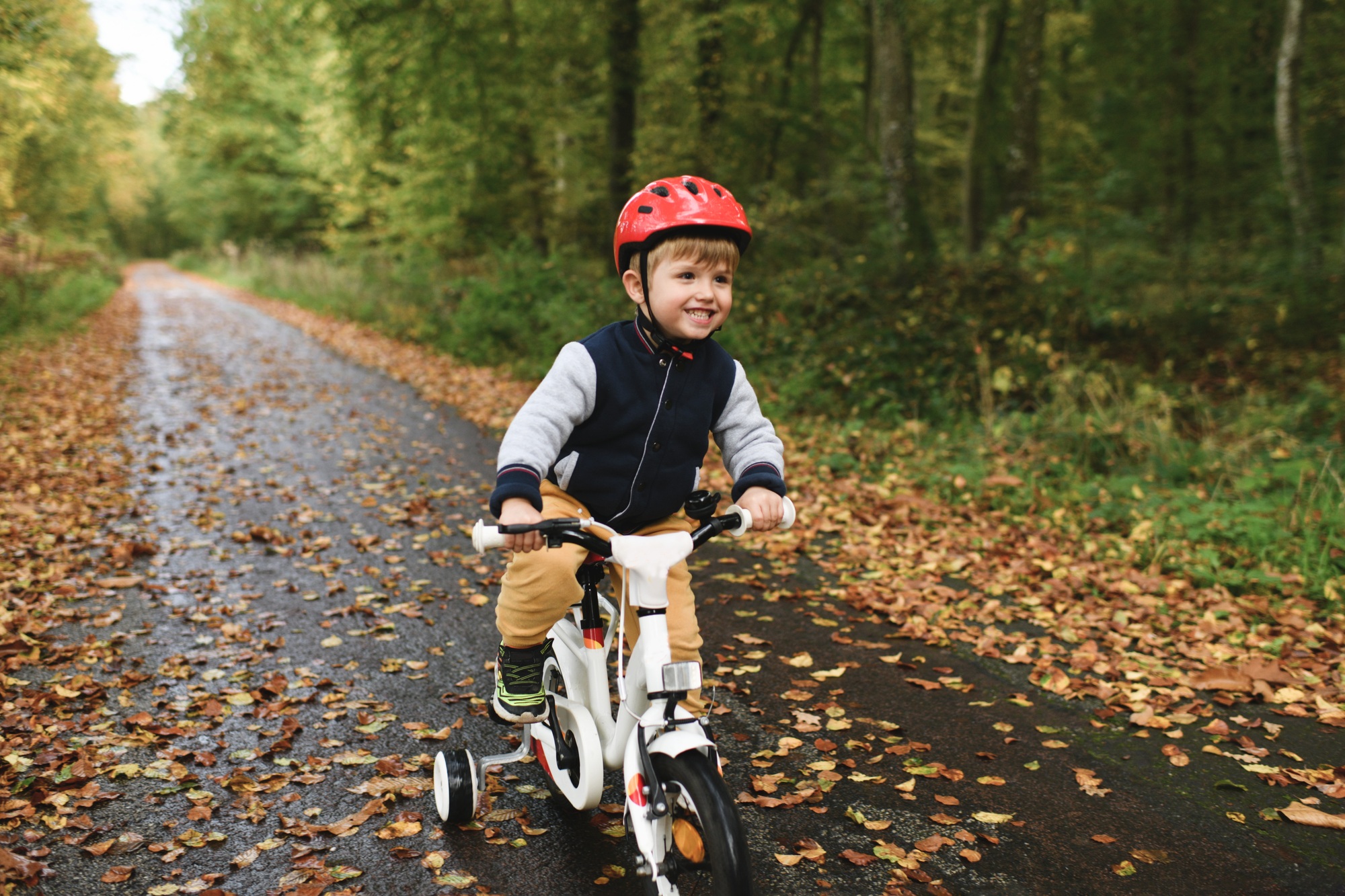 A boy learns riding a four-wheeled bicycle