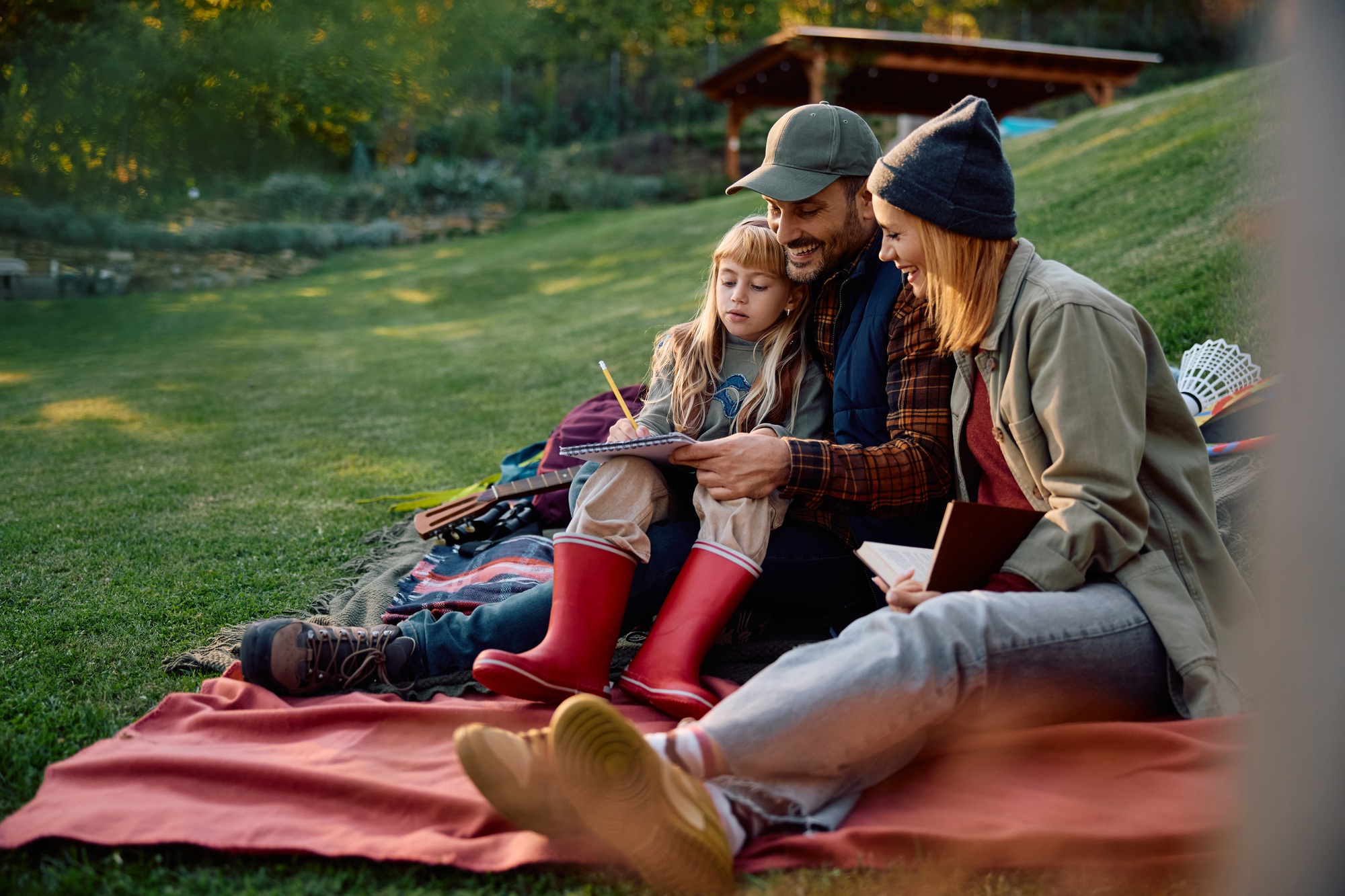 Happy family drawing while enjoying in autumn day at the park.