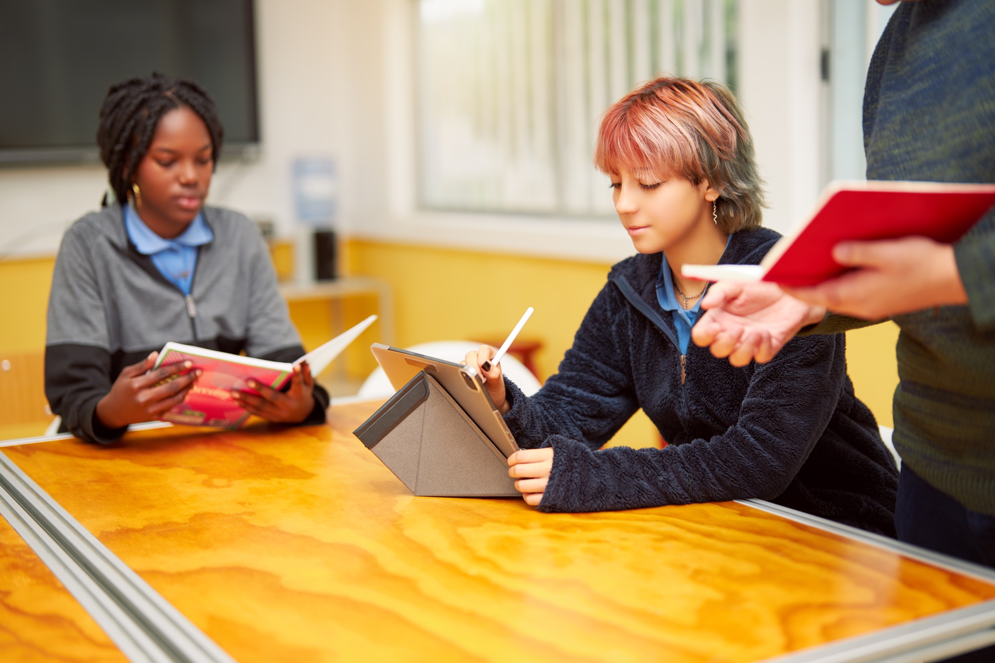 high school students working in class and teacher explaining the subject