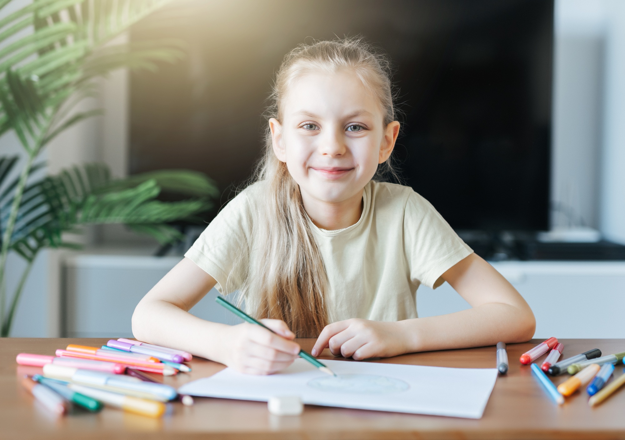 Child girl drawing with colorful pencils