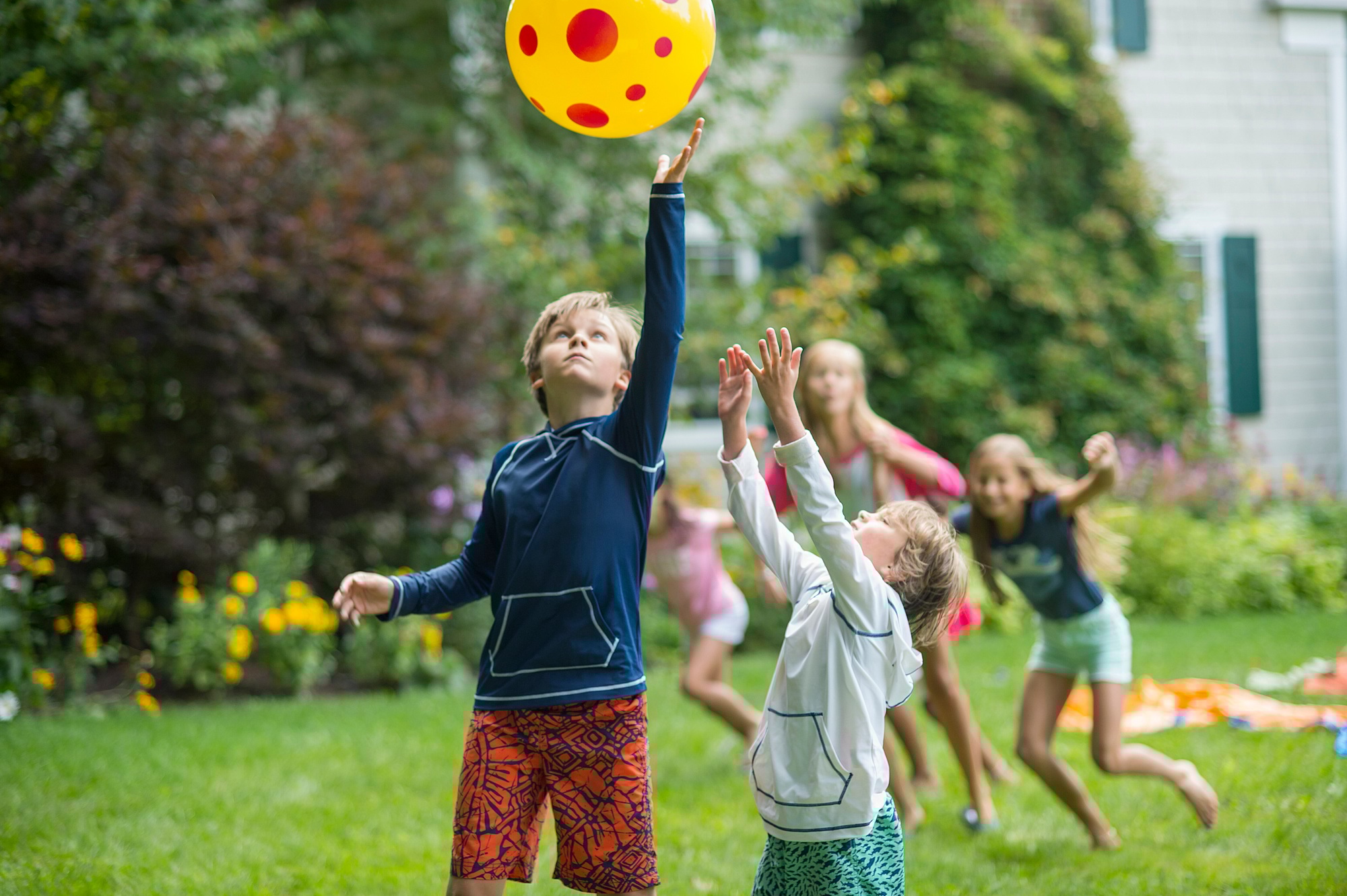 Children playing ball game in garden