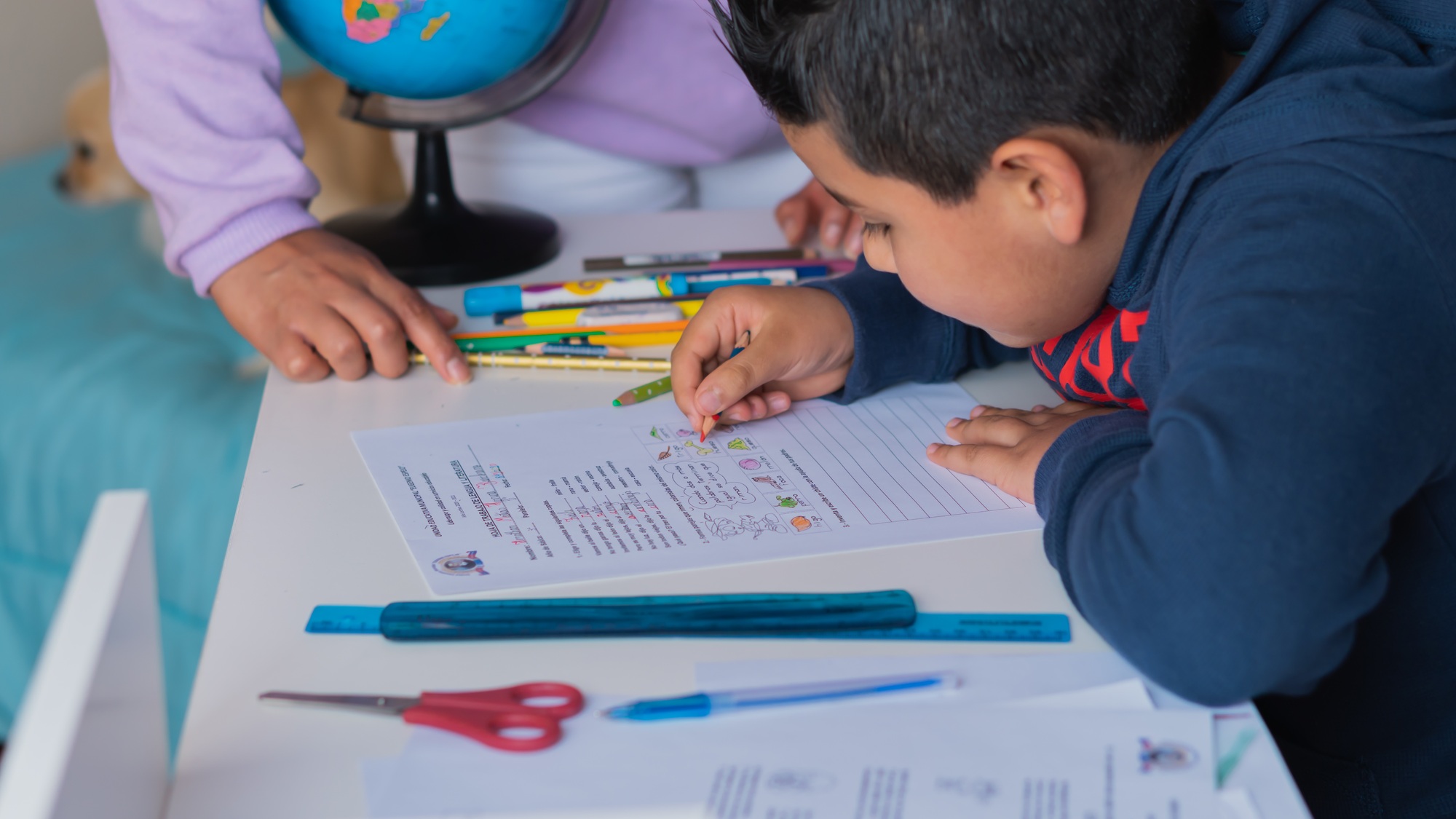 Closeup of a Hispanic child studying at home with his teacher