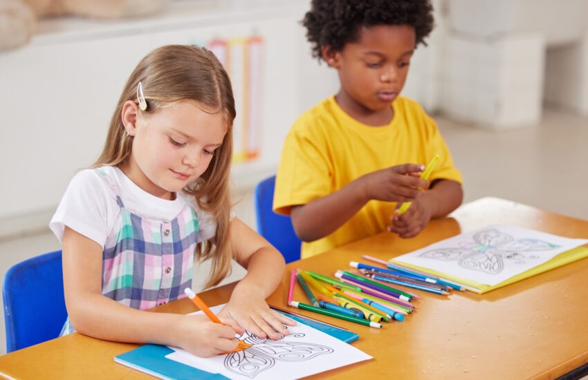 Colouring is a great sitting still activity. Shot of preschool students colouring in class.