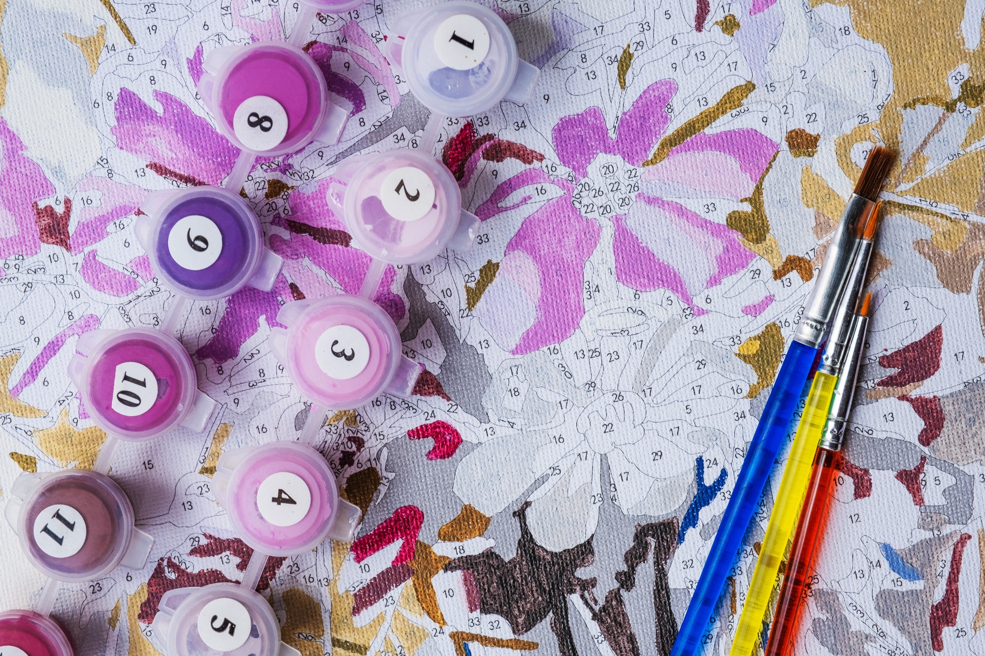 Painting by numbers. Drawing on canvas. Numbered paint cans and brushes.