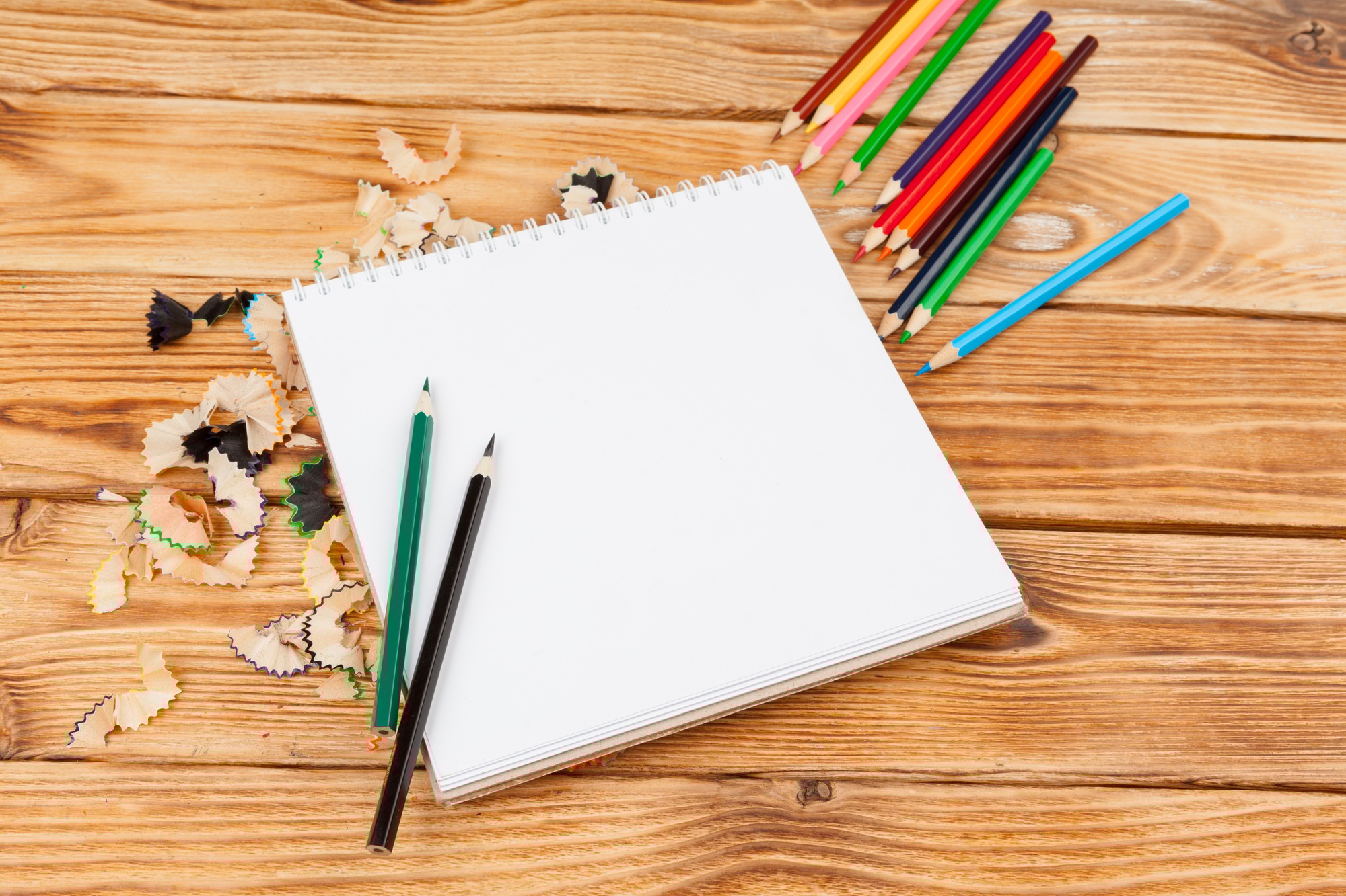 Pencils, pencil cuts and blank paper on a desk table