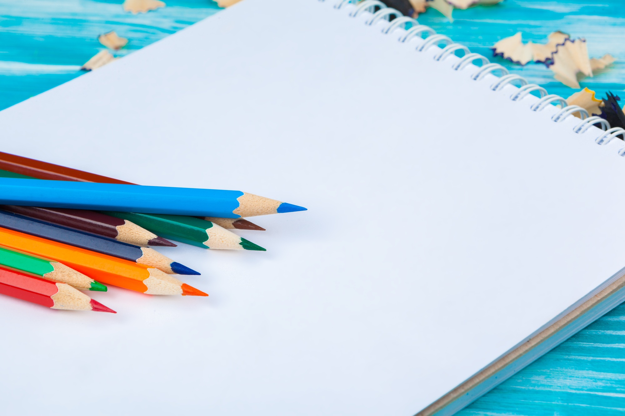 Pencils, pencil cuts and blank paper on a desk table